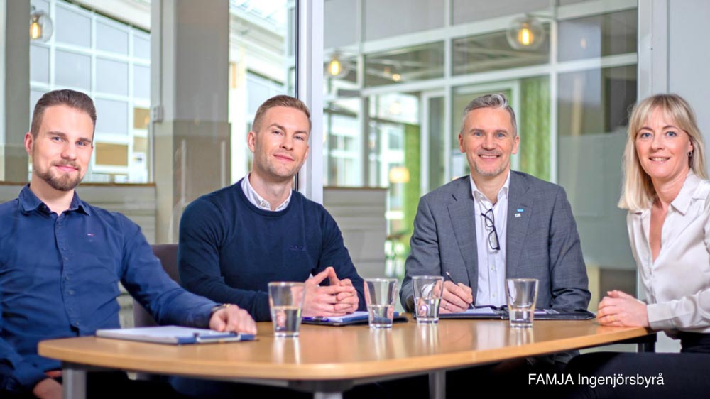 Ingenjörer från FAMJA sitter vid ett bord och ler mot kameran
